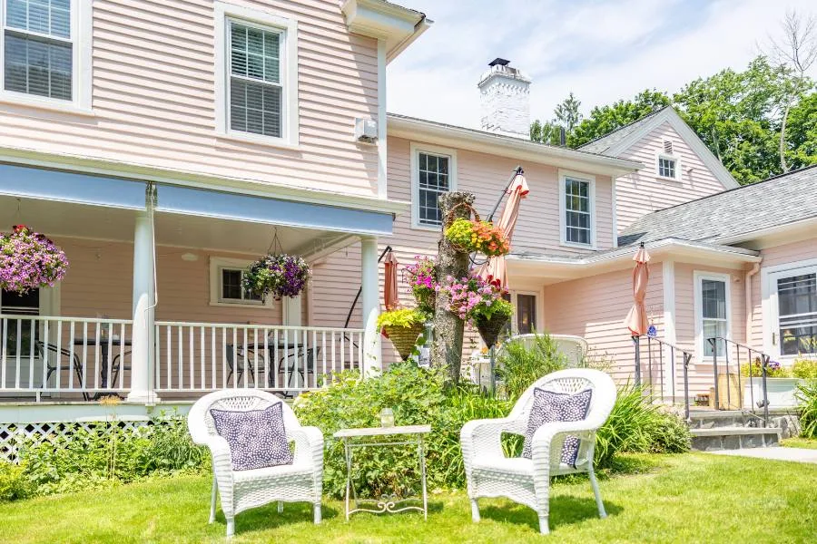 Two white chairs in front of the Inn at Stockbridge in spring